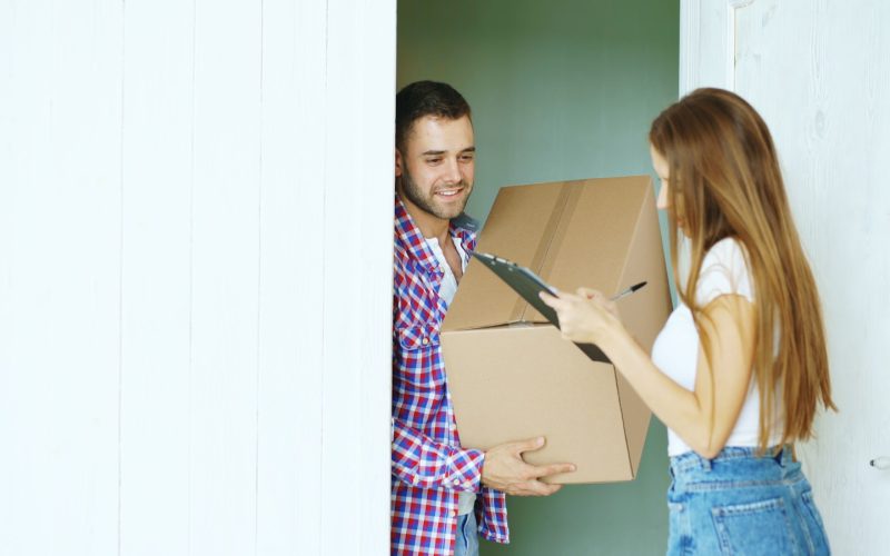 En Mensajería Nolasco, nos dedicamos a ofrecer soluciones integrales de mensajería, recadería y reparto en Granada Couple signing for a package delivery at the door